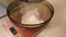 The flour is sifted through a sieve to make the pastry