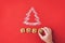 Flour Silhouette Christmas Tree with cookies digits 2020 on red background with women hand. Delicious bakery sweet confectionery