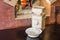 Flour spilling out of a wooden windmill on the background of a Russian stove