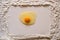 Flour sprinkled on a wooden table, with a smooth rectangular print and a raw egg in the center. Copy space.
