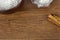 Flour in a wooden bowl  a small sieve and cinnamon sticks on a wooden table