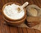 Flour in wooden bowl and wheat in burlap bag.