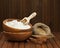 Flour in wooden bowl and wheat in burlap bag.