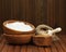 Flour in wooden bowl and wheat in burlap bag.