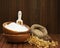 Flour in wooden bowl and wheat in burlap bag.