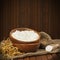 Flour in wooden bowl and wheat in burlap bag.