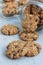 Flourless gluten free peanut butter, oatmeal and chocolate chips cookies in glass jar and on the table, vertical