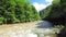 Flow of the stream in the middle of the mountains with green trees