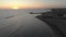 Flow at sunset over silky sea with city skyline and approaches off to jetty