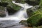 Flow of water through boulders covered with moss