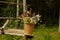 Flower basket in the forest hanging on wooden poles