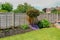 Flower bed in the back-garden with a fence behind the plants.