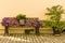 Flower bench with flowerpot and colorful flowers in front of bright house wall on cobblestones