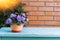 Flower bouquet in vase in front of stone wall. Outdoor arrangement of flowers