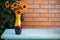 Flower bouquet in vase in front of stone wall. Outdoor arrangement of flowers