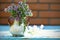 Flower bouquet in vase in front of stone wall. Outdoor arrangement of flowers