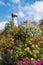 Flower column with petunias and alyssum, church tower. tourist resort Gmund