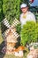 Flower Festival. Mature woman among pots with arborvitae and pottery