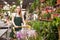 Flower market. Seller delivers potted flowers on a pushcart