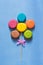 Flower of multicolored macaroons. Blue painted background. The concept of a holiday.