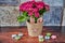 Flower pot with a rabbit face and small fabric flowers in focus