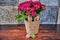 Flower pot with a rabbit face and small fabric flowers in focus