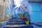 Flower pots on blue street in Chefchaouen, Morocco