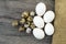 Flower-shaped chicken eggs and quail eggs.White chicken eggs and quail eggs stand side by side on a wooden floor