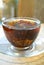 Flowering tea in the transparent cup on transparent saucer, the steam from the hot tea