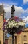 Flowerpot with colorful flowers hanging from ornamental lantern