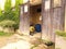 Flowerpot crate in the foreground and storage of garden materials, behind a large worn wooden door