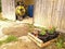 Flowerpot crate in the foreground and storage of garden materials, behind a large worn wooden door