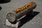 Flowerpot with orange flowers annuals from carved spruce logs. The hollow trunk lined with stones serves as an improvised flowerpo