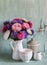 Flowers asters in a white enameled pitcher and vintage crockery - ceramic bowl and enameled jar, on a blue wooden background.