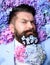 Flowers in the beard. Bearded man with a decorated beard for the Spring holiday.