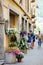 Flowers blossoming in flower pots on old cobblestone street with souvenir shops, restaurants and cafes in Como town, Lake Como,