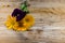 Flowers calendula and violets with a stem from above on a wooden board