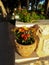 Flowers in clay pot on the street in the yard. Stylish pot on a stone wall, vertical photo