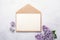 Flowers composition. Envelope, sheet of paper and lilac flowers and on stone background. Template for your invitation or