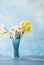 Flowers of daffodils of different kinds in a blue vase