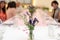 Flowers decorate on the dinning long table in the luxury relax event with the blur social people behind