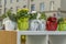 Flowers in decorated pots on shelf outdors