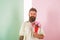 Flowers delivery concept. Man with beard calm face holds bouquet fresh flowers. Delivery man with flowers. Hipster with