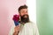 Flowers delivery concept. Man with beard cheerful face holds bouquet fresh flowers. Hipster with beard ready holiday