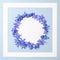 Flowers frame concept. Blank circle with empty space bordered blue flowers petals. Minimalistic flat lay composition. Top view.