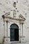 Flowers growing luxuriantly over the main entrance to church in Old Omis city, Dalmatia, Croatia