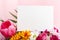 Flowers mock up congratulation. Congratulations card in bouquet of flowers on pink background. White blank card with space for