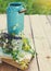 Flowers near watering can with old books on a rustic wooden table