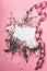 Flowers and petal arrangement around blank paper on pink background with ribbons, top view. Love feeling letter. Instagram style.