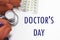 Flowers, phonendoscope and tablets - a banner with inscription Doctor's Day on white.